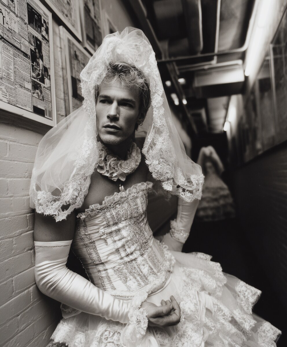 Black and white portrait of a person in bridal dress backstage